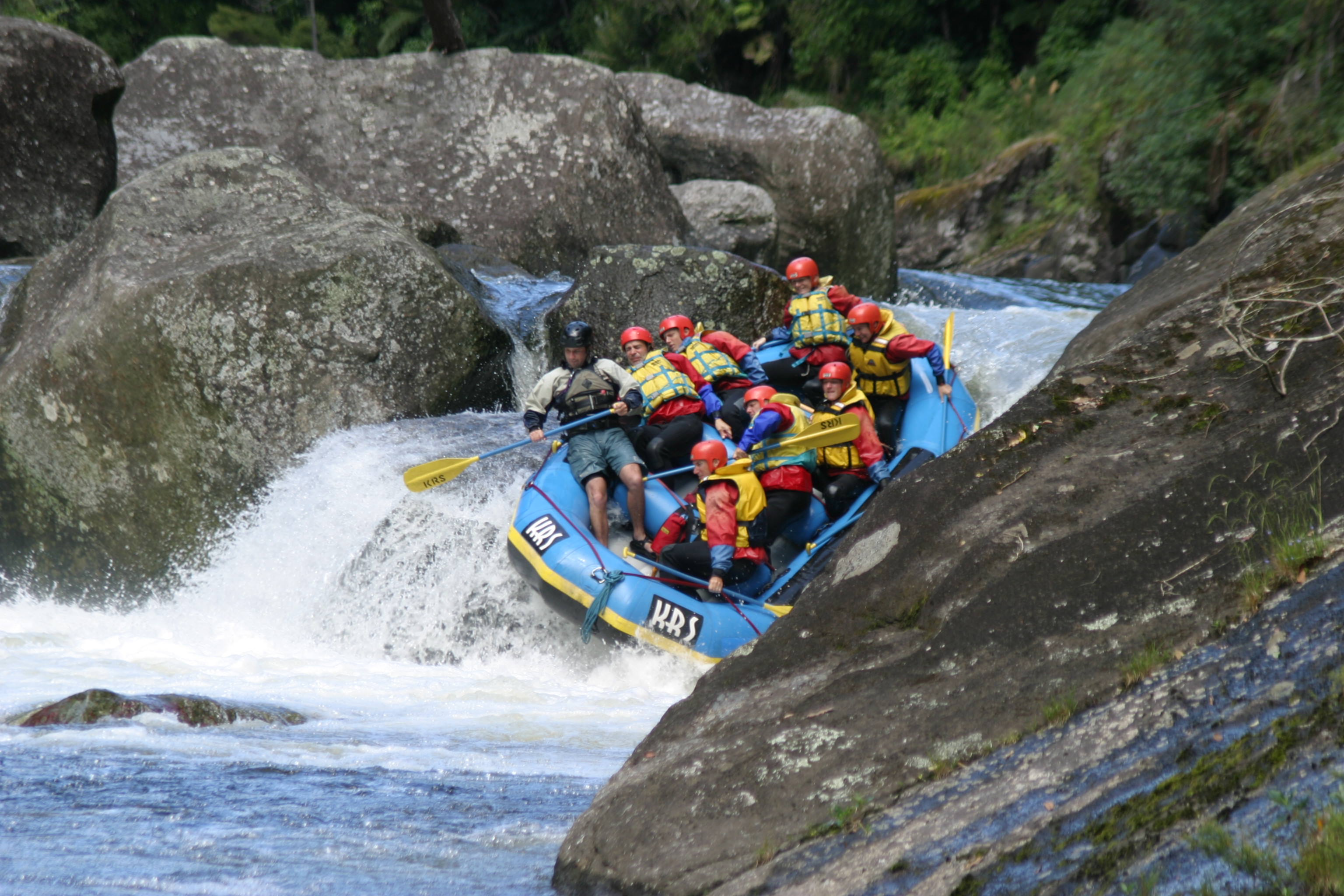 River raft dropping down a small waterfall. 